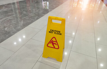 Yellow Caution wet floor sign on wet floor