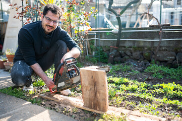 Woodcutter using a chainsaw to cut a wood log