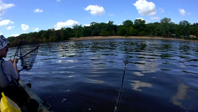 Wide angle headcount view while catching sturgeon from kayak while fishing on the river.