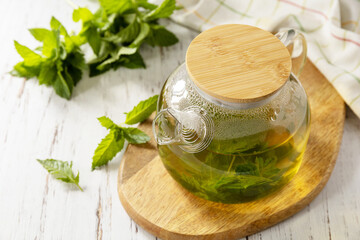 Organic aromatherapy relaxation medical healthy drink. Teapot of fresh natural herbal tea with...