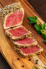 Vertical shot of Sesame crusted yellow fin tuna steak on wooden board
