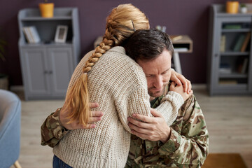 Candid portrait of girl embracing military dad at home in bonding moment