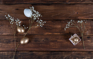 Golden eggs with branch of flowers  on wooden background