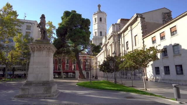 Valladolid, Spain - November 12 2022: Plaza de la Universidad Square in the center of Valladolid. In background is the cathedral of Valladolid. Beautiful park for recreation near cathedral. Stabilized