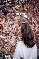 portrait of a woman in pink blossoming park