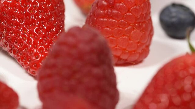 un bel mix di frutti rossi per la dieta, lamponi fragole  mirtilli su sfondo bianco.