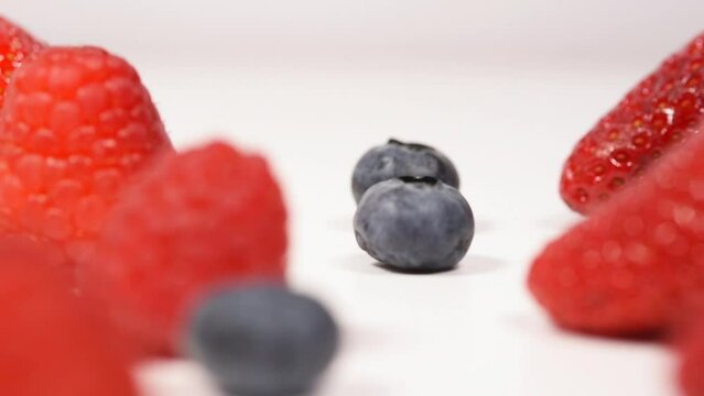 un bel mix di frutti rossi per la dieta, lamponi fragole  mirtilli su sfondo bianco.