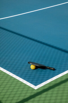Pickleball Court with Paddle and Yellow Ball