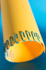 Blue paper clip holding an orange cardboard in a circular shape.