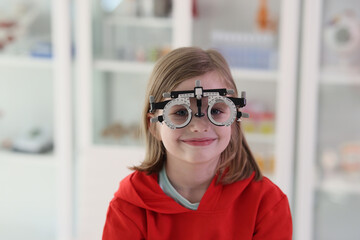 Girl with eye examining tool at ophthalmologist appointment