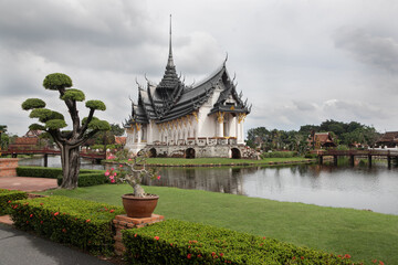 Panoramic photo of the architectural park of Oriental culture. Religious buildings of Thai history: palace and temple complexes. The exhibits are surrounded by ponds, tropical greenery and flowers