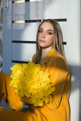 Portrait of a girl with long hair and a bouquet of yellow tulips 4594.