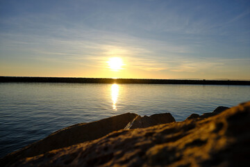 sunset at the sea in front of a dike