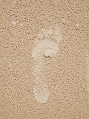 Footprint of a barefoot in the white sand