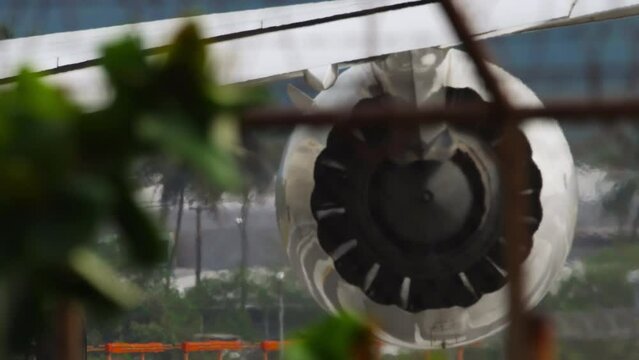 Jet engine closeup view of fan. Aircraft view through airport fence. Airplane on the runway preparing for takeoff