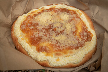 Typical apricot moravia cake in old brown paper on meadow
