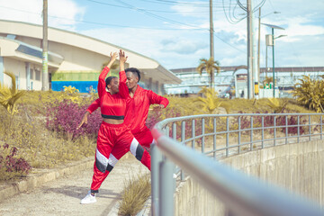 Fototapeta premium Pareja de bailarines afro realizan actuacion de baile en parque con hermosa vegetacion y hermoso cielo azul