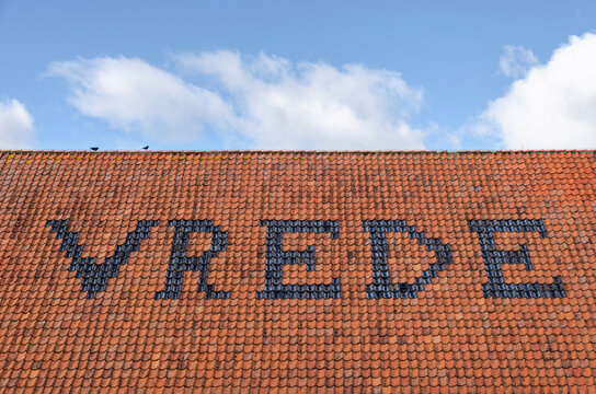 Zaandam, The Netherlands, February 26, 2023: roof of a farm at Zaanse Schans neighbourhood with in roof tiles the Dutch word "Vrede" (peace)