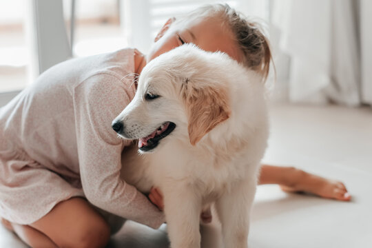 child girl play hugging dog puppy golden retriever, pet therapy and canisterapy for adults and children. animal canis assisted therapy. kids emotion mental health friends love tightly cuddle