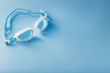 Fototapeta na wymiar White swimming glasses with a blue lens