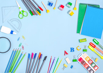 Stationery, notepads, paints, felt-tip pens, markers with place for text on a blue background.