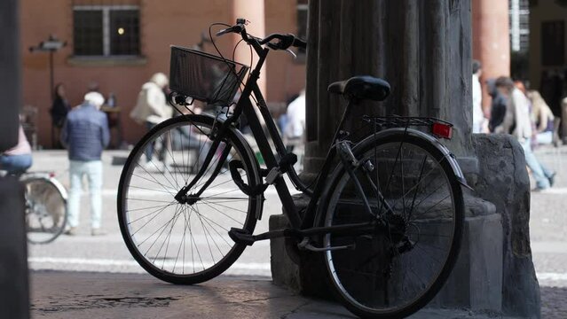 Bicycle leaning on old European column. Bike parked outside. Urban alternative transportation
