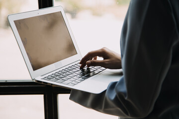 Attractive smiling young asian business woman work at home office, Asian woman working on laptop computer holding tablet.