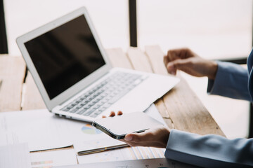 Attractive smiling young asian business woman work at home office, Asian woman working on laptop computer holding tablet.