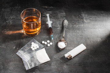 Alcohol drink in a glass, syringe with a dose of drugs, white pills in a transparent bag and...