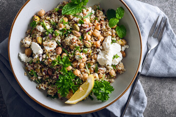 Healthy Salad made from Quinoa, Cucumber, Herbs, Pistachios, Chickpeas and Feta with lemon juice and olive oil. So called Jennifer Aniston Salad, fresh, crunchy, and packed with plant-based protein