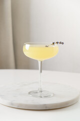 Glass of fresh cocktail with lavender on white kitchen background. Vertical format. Close up.