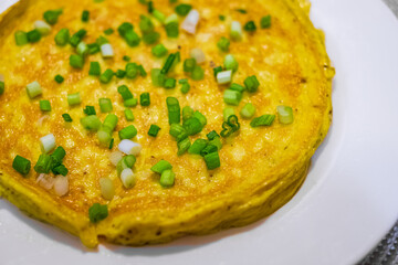 Simple egg omelette with herbs. Fluffy breakfast omelette with green spring onions. Breakfast with pan-fried eggs