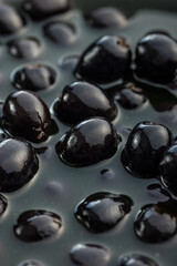 Pitted black olives. Marinated olives in the pickle.