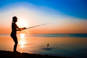 A Happy girl fisherman catches fish by the sea on nature silhouette travel