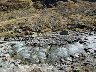 Mountain stream Aua da Grialetsch in the beautiful autumn setting of the alpine valley Val Grialetsch of the Albula Alps massif, Zernez - Canton of Grisons, Switzerland (Kanton Graubünden, Schweiz)