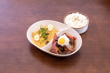Fototapeta na wymiar Tray of Peruvian mixed plate of lomo saltado, aji de gallina and white rice