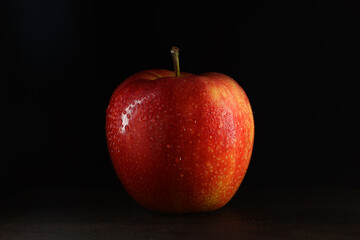 an apple on a black background with water drops. Selective focus.