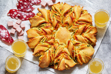 Table for a friendly party, snack star bread with cheese filling, sausage and beer.