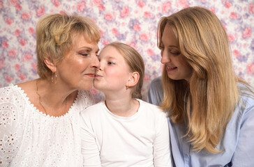 Portrait of a daughter and an elderly mother, her daughter kisses her.