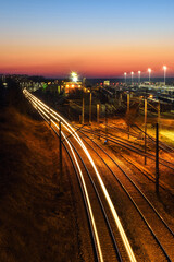 Obraz na płótnie Canvas Railway station in the evening scenery. Railroad tracks at Kielce Herby station, Poland.