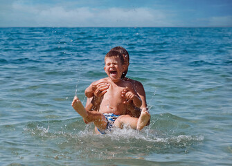 Joyful father and son having fun in water on  beach in Croatia.Summer vacation.Happy lifestyle childhood concept - 585928511