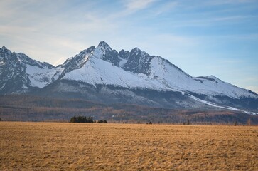 Beautiful, mountainous, spring panorama. White snow-covered peak in the Slovak Tatra Mountains. Photo taken in the village of Nova Lesna, Slovakia.