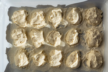 Italian homemade gnocchi dough with ricotta, flour and butter. Italian food. White plate. Dark background. small balls made with ricotta cheese