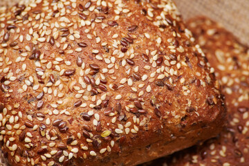 Two freshly baked rustic square shaped bread buns with sesame seeds extremely close up high detail view