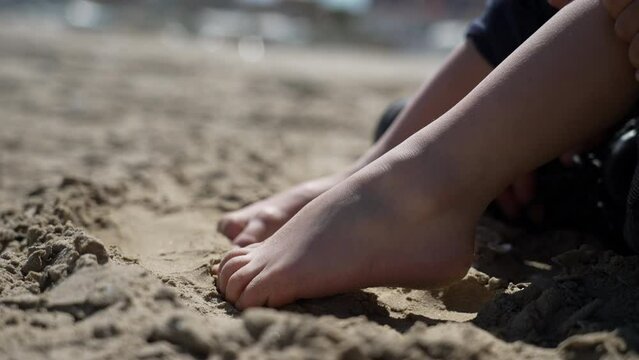 Child foot on sand outside. Closeup kid barefoot feet at beach feeling nature