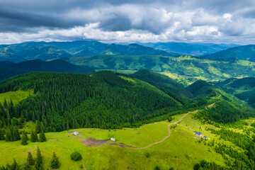 Aerial view of beautiful mountain forest covered with fluffy clouds.