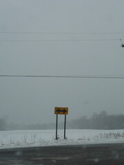 Road sign in desolate snowy winter landscape