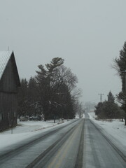 winter road in the snow with old barn