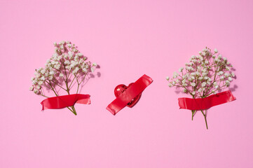 Bouquet of white gypsophila  and red textile hearts on a pink background, top view