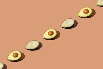Arranged avocado on a brown cream background. Pattern.